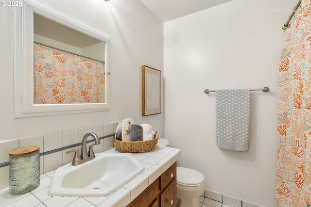 bathroom with toilet, tile patterned flooring, and vanity