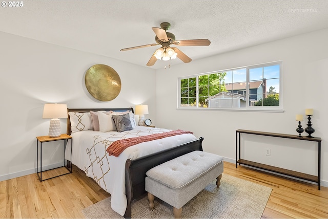 bedroom with wood finished floors, baseboards, and ceiling fan