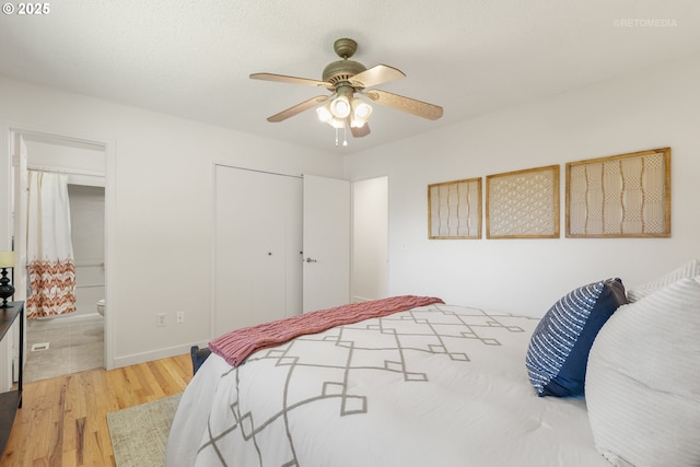 bedroom with wood finished floors, a closet, connected bathroom, ceiling fan, and baseboards