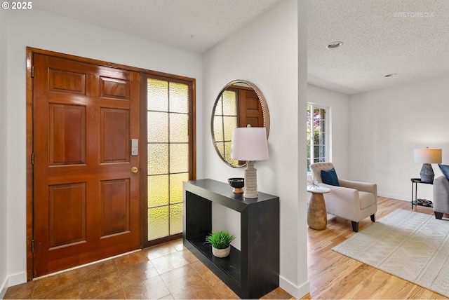 foyer with a textured ceiling and baseboards