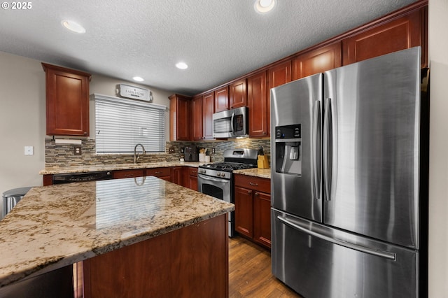 15574 Bachelor Ave, Sandy, OR 97055 - kitchen featuring appliances with stainless steel finishes, decorative backsplash, a textured ceiling, dark wood-style floors, and light stone countertops