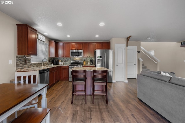15574 Bachelor Ave, Sandy, OR 97055 - kitchen with appliances with stainless steel finishes, dark wood-style floors, decorative backsplash, open floor plan, and recessed lighting