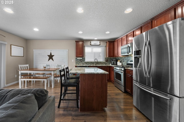 15574 Bachelor Ave, Sandy, OR 97055 - kitchen with appliances with stainless steel finishes, tasteful backsplash, a textured ceiling, recessed lighting, and light stone counters