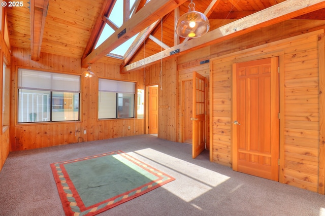 carpeted spare room featuring wooden walls and wood ceiling