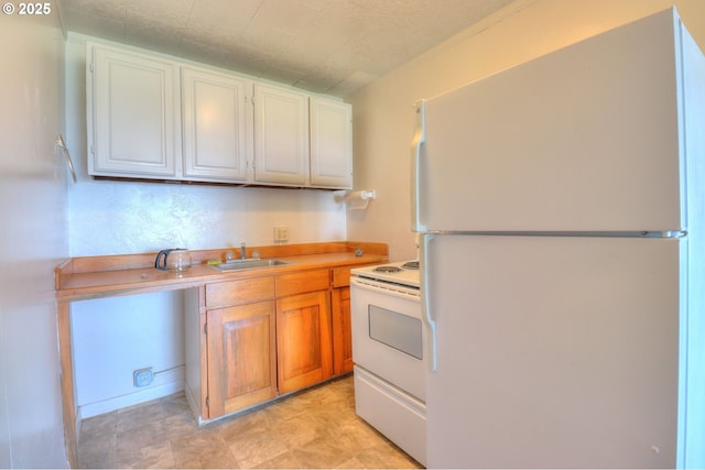 kitchen with white appliances, a sink, light countertops, and white cabinets