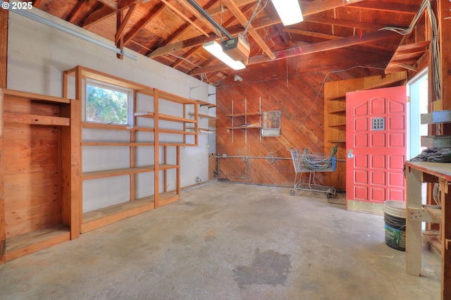 garage with wooden walls and a garage door opener