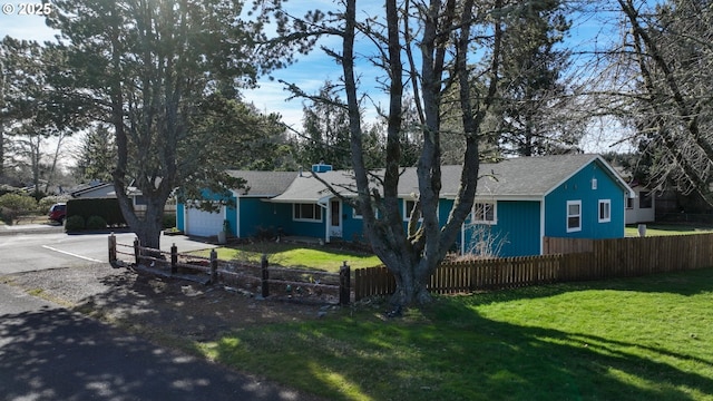 view of front of house with a garage, driveway, a fenced front yard, and a front yard