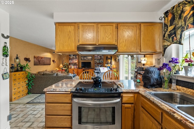 kitchen with stainless steel range with electric stovetop, under cabinet range hood, a peninsula, open floor plan, and a sink