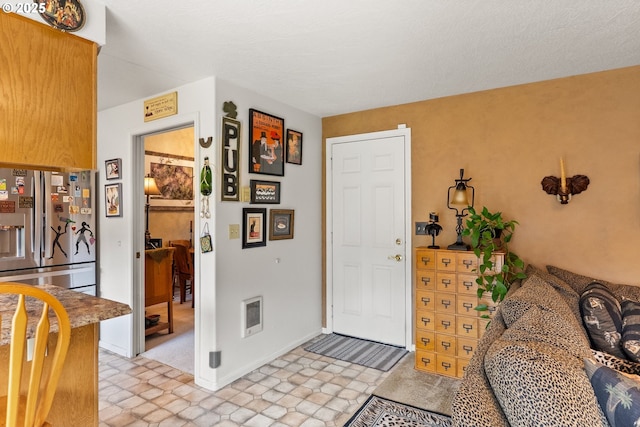 foyer featuring stone finish flooring and baseboards
