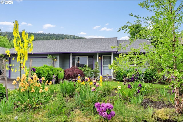 view of front of house with an attached garage and a shingled roof