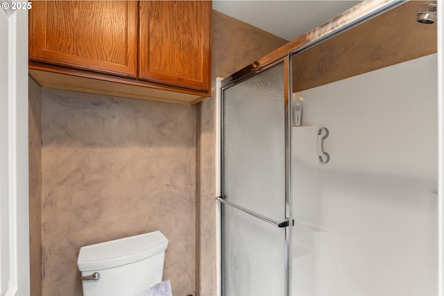 full bath featuring a shower with shower door and toilet
