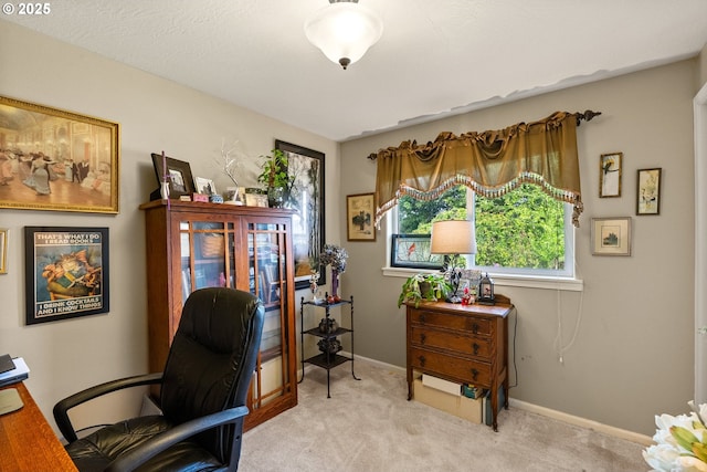 carpeted home office featuring baseboards