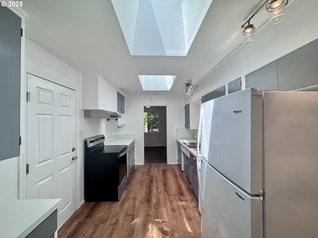 337 Spruce Dr, Brookings, OR 97415 - kitchen featuring freestanding refrigerator, electric range, a skylight, light countertops, and dark wood-style flooring