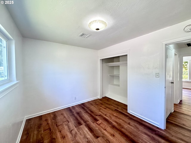 337 Spruce Dr, Brookings, OR 97415 - unfurnished bedroom with dark wood finished floors, baseboards, and a closet