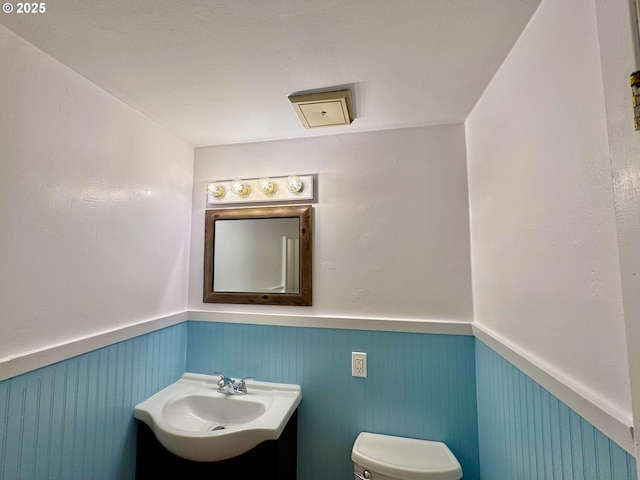 337 Spruce Dr, Brookings, OR 97415 - bathroom featuring a wainscoted wall, vanity, and toilet