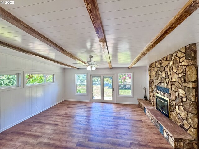 337 Spruce Dr, Brookings, OR 97415 - unfurnished living room featuring a stone fireplace, a ceiling fan, baseboards, and wood finished floors