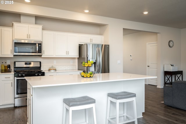 kitchen with white cabinetry, appliances with stainless steel finishes, dark wood finished floors, and light countertops