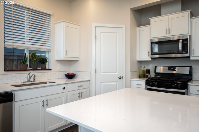 kitchen featuring stainless steel appliances, light countertops, and a sink