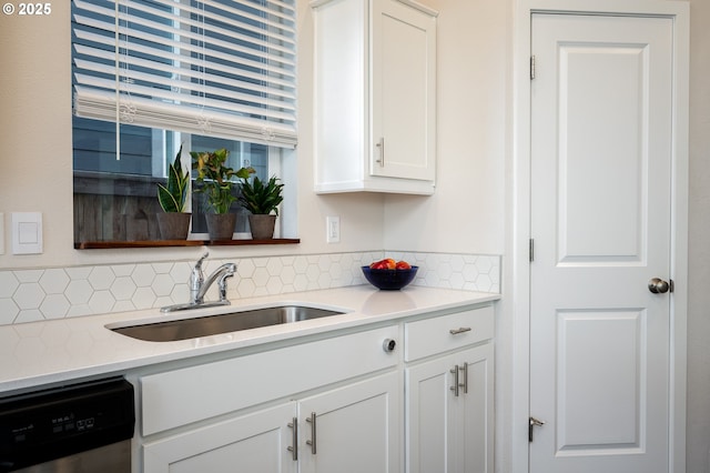 kitchen featuring a sink, decorative backsplash, dishwasher, and white cabinets