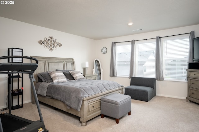 bedroom with light carpet, visible vents, and baseboards