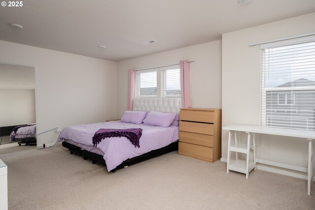 bedroom featuring visible vents and light colored carpet