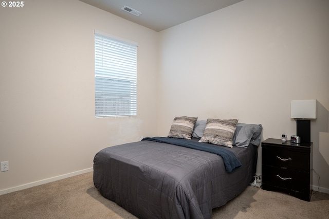 bedroom featuring light colored carpet, visible vents, and baseboards