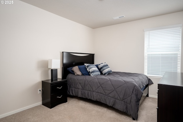 bedroom featuring light carpet, visible vents, and baseboards