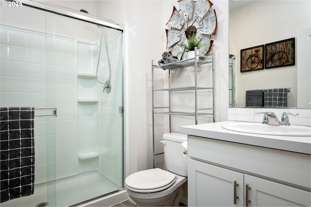 full bath with vanity, toilet, and a stall shower