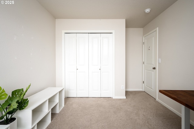 unfurnished bedroom featuring a closet, baseboards, and carpet