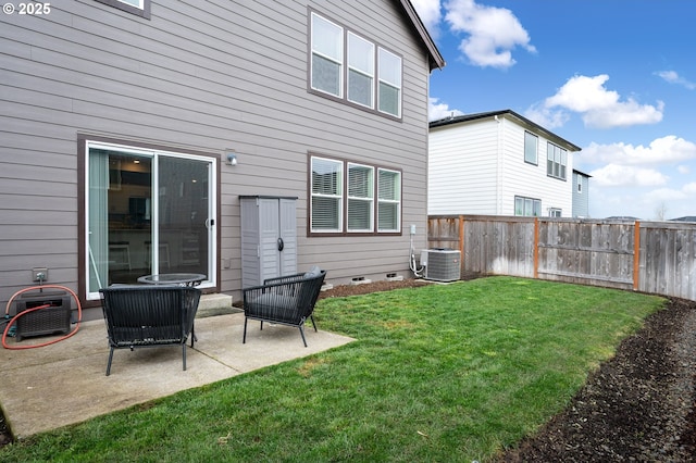 rear view of house featuring cooling unit, fence, crawl space, a patio area, and a lawn