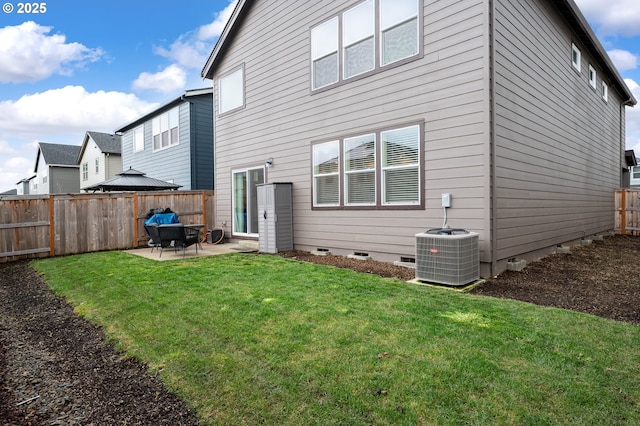 rear view of house featuring a lawn, central AC, a fenced backyard, crawl space, and a patio area