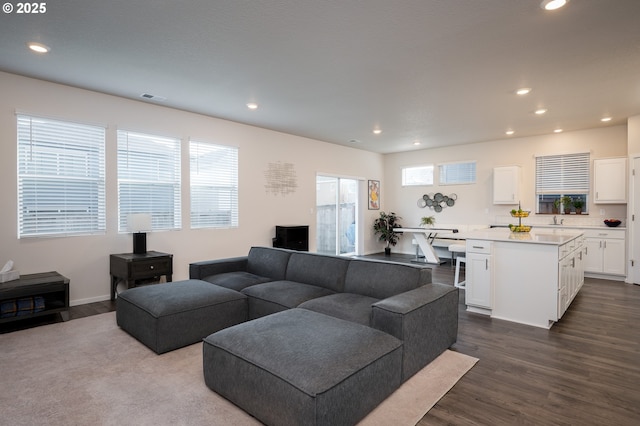 living room with recessed lighting, visible vents, and dark wood finished floors