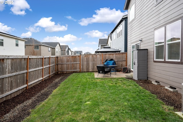 view of yard featuring a patio, a fenced backyard, and a residential view