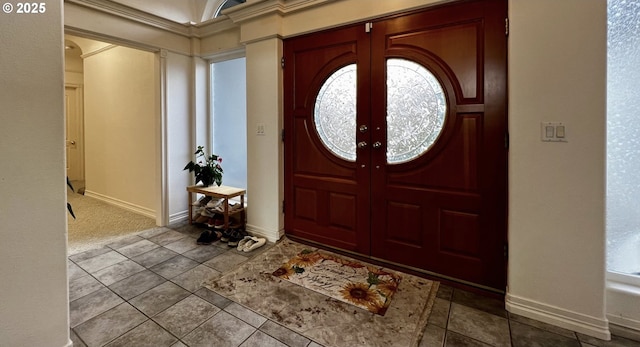 tiled foyer entrance featuring baseboards and french doors