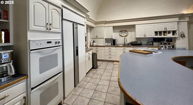 kitchen featuring open shelves, backsplash, white cabinetry, light tile patterned flooring, and white appliances