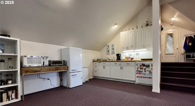 kitchen with dark carpet, white cabinetry, vaulted ceiling, and stove