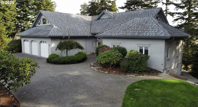 exterior space with a garage, driveway, and stucco siding