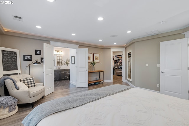 11712 Finnegans Way, Oregon City, OR 97045 - bedroom with a walk in closet, wood finished floors, connected bathroom, recessed lighting, and a closet