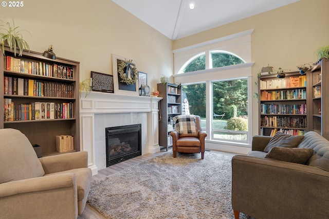 11712 Finnegans Way, Oregon City, OR 97045 - living area with high vaulted ceiling, a tiled fireplace, and wood finished floors