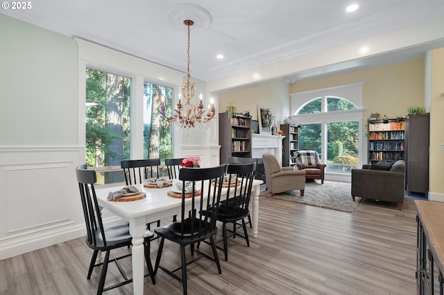 11712 Finnegans Way, Oregon City, OR 97045 - dining area featuring a decorative wall, ornamental molding, a chandelier, a wainscoted wall, and light wood-type flooring