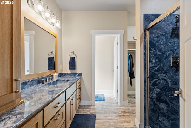 875 12th St SW, Bandon, OR 97411 - bathroom featuring wood finished floors, vanity, a shower stall, and a walk in closet