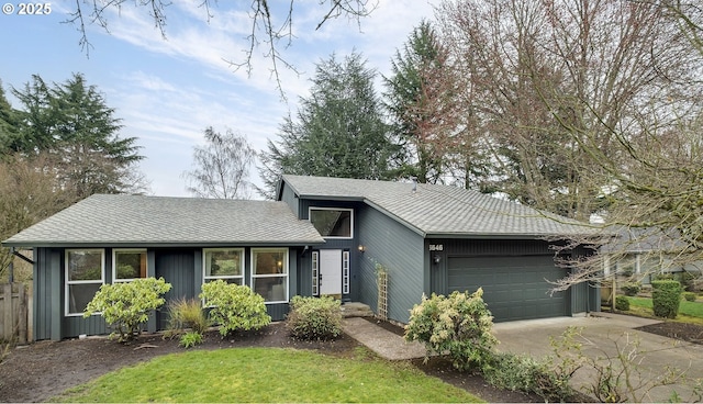 view of front facade with concrete driveway, an attached garage, and roof with shingles