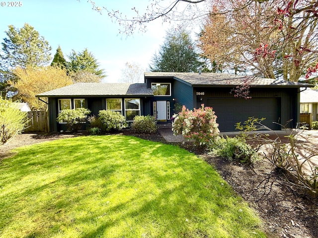 view of front of property with driveway, a garage, fence, and a front lawn