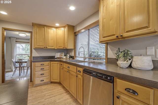 kitchen with recessed lighting, dark countertops, stainless steel dishwasher, light wood finished floors, and a sink