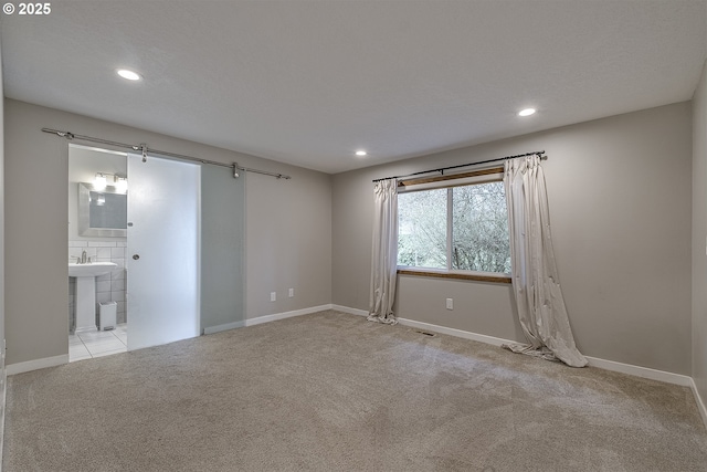 spare room with recessed lighting, carpet, visible vents, and baseboards