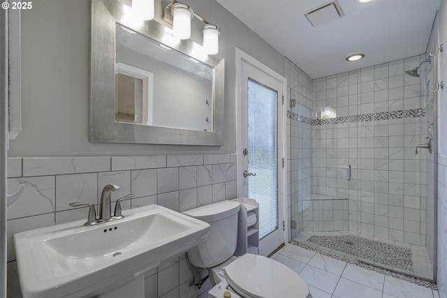 full bath with visible vents, toilet, a stall shower, marble finish floor, and a sink