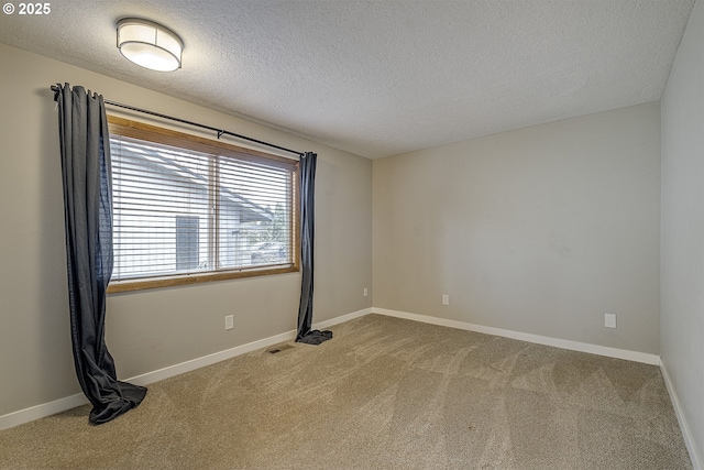 carpeted empty room with visible vents, baseboards, and a textured ceiling