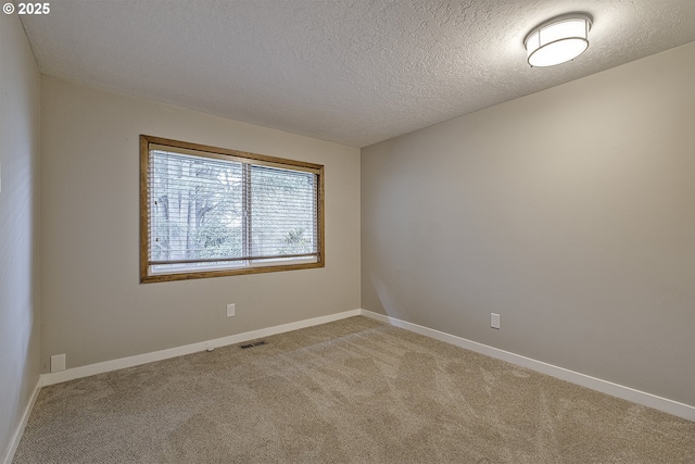 carpeted empty room featuring visible vents, baseboards, and a textured ceiling