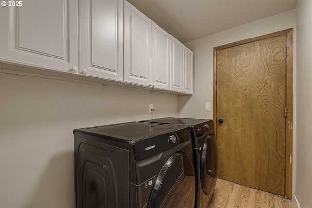 washroom featuring cabinet space, light wood-style flooring, and washer and dryer
