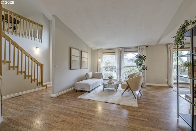 living area featuring stairs, baseboards, and wood finished floors